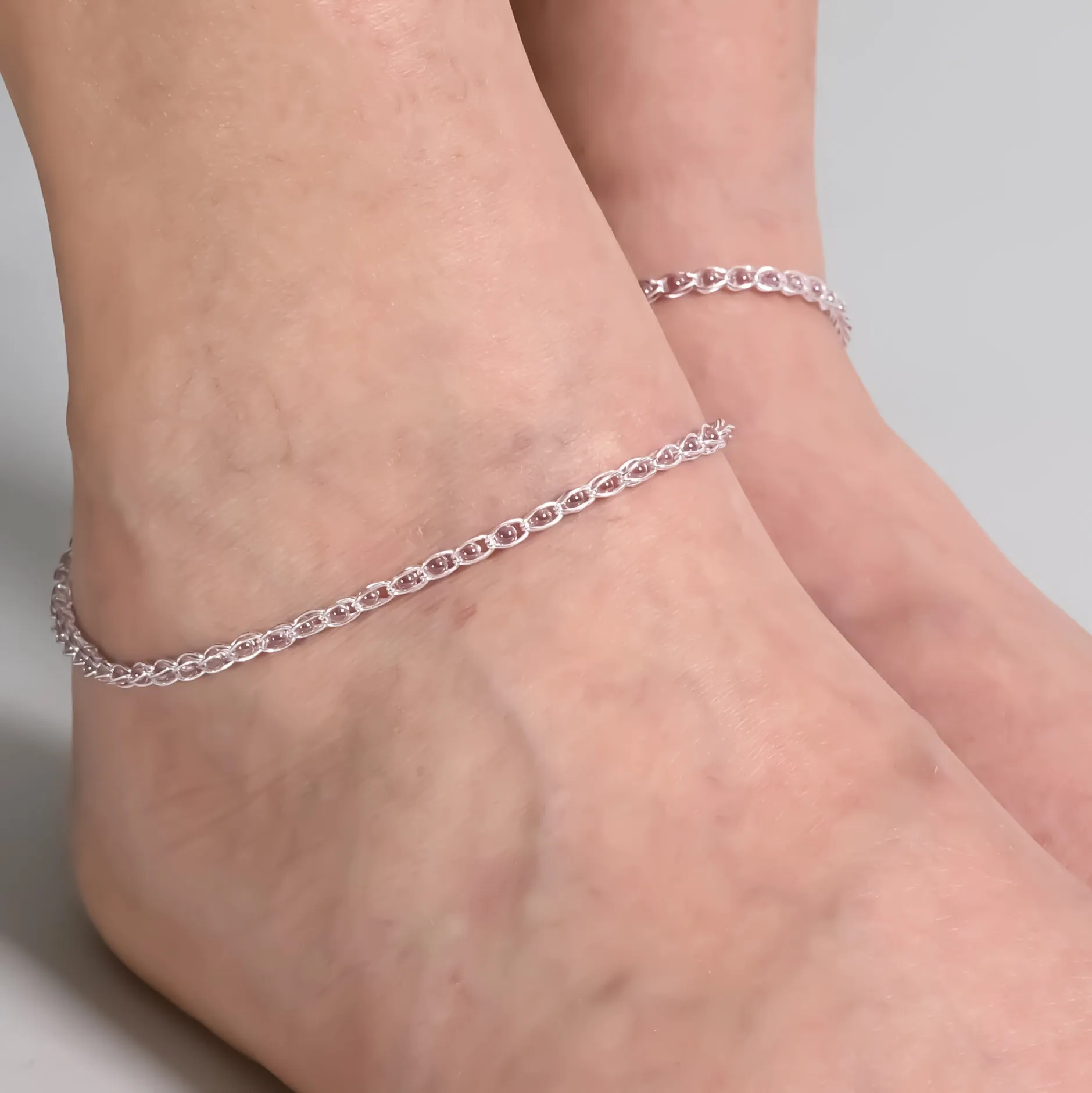 Silver Anklet Adorned with Pink Buds Inside Graceful Cage